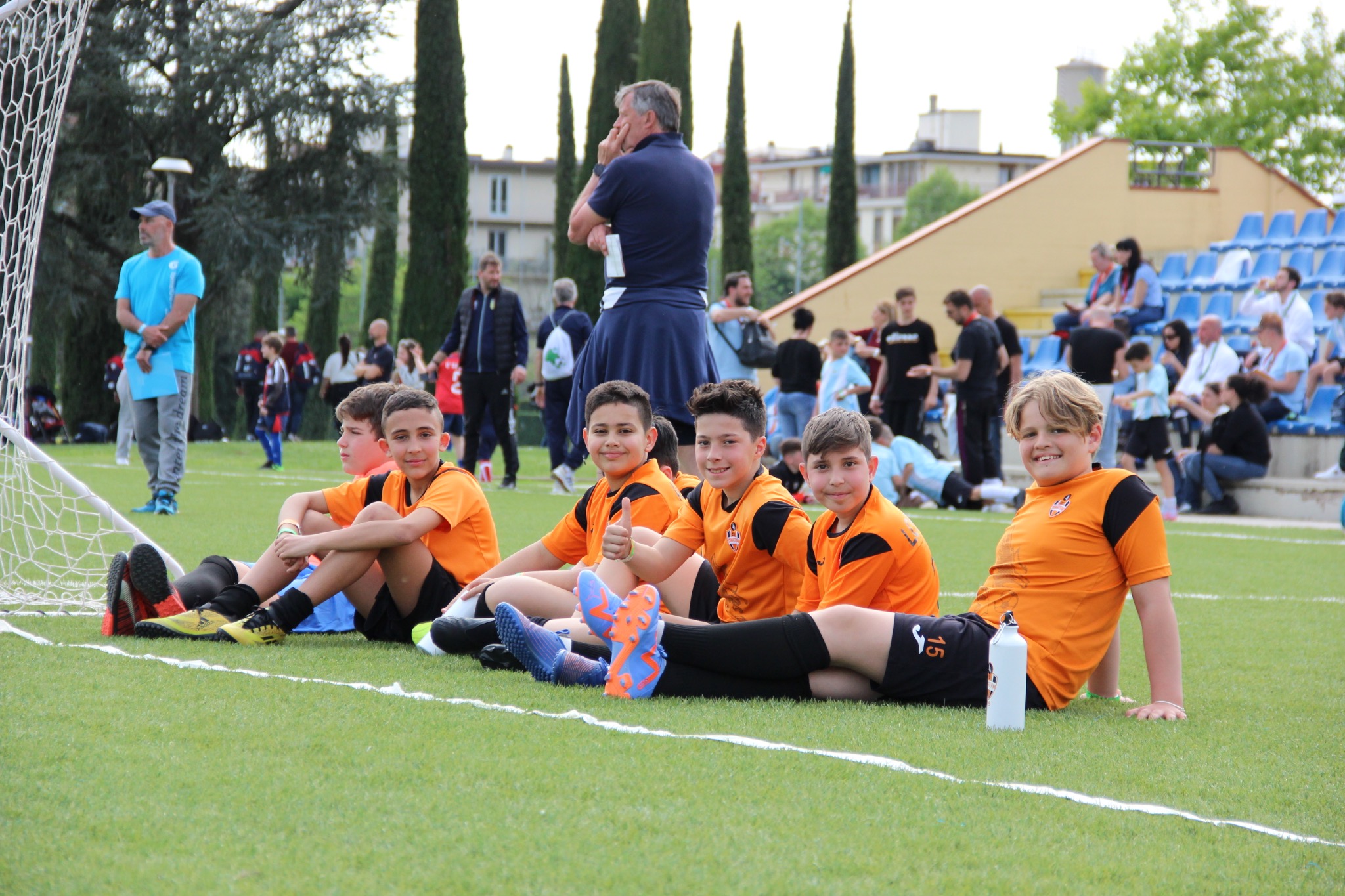 Ragazzi Dimateam seduti a bordo campo durante una giornata di attività